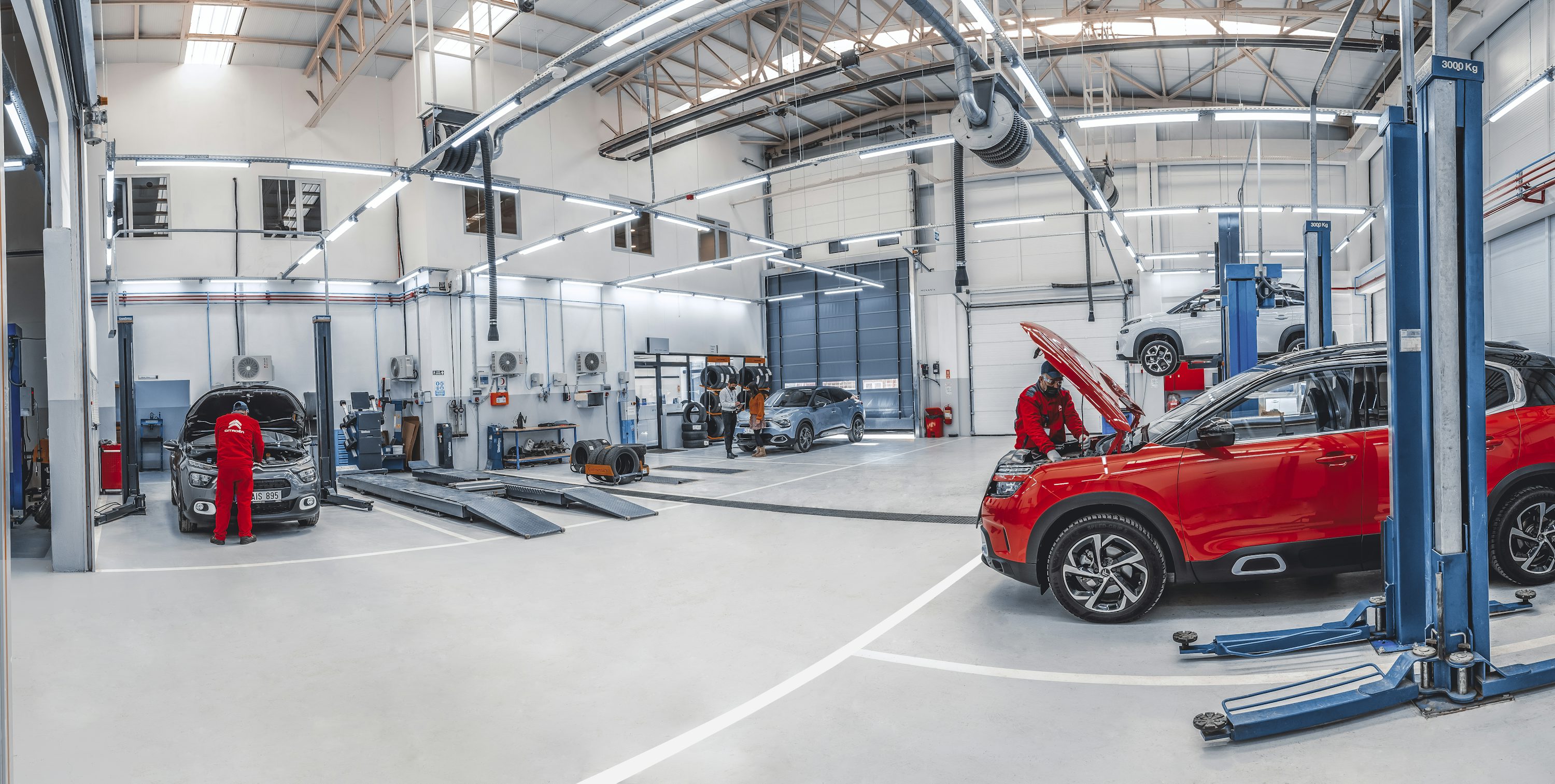 Helle Servicehalle mit Fahrzeugen und Hebebühnen